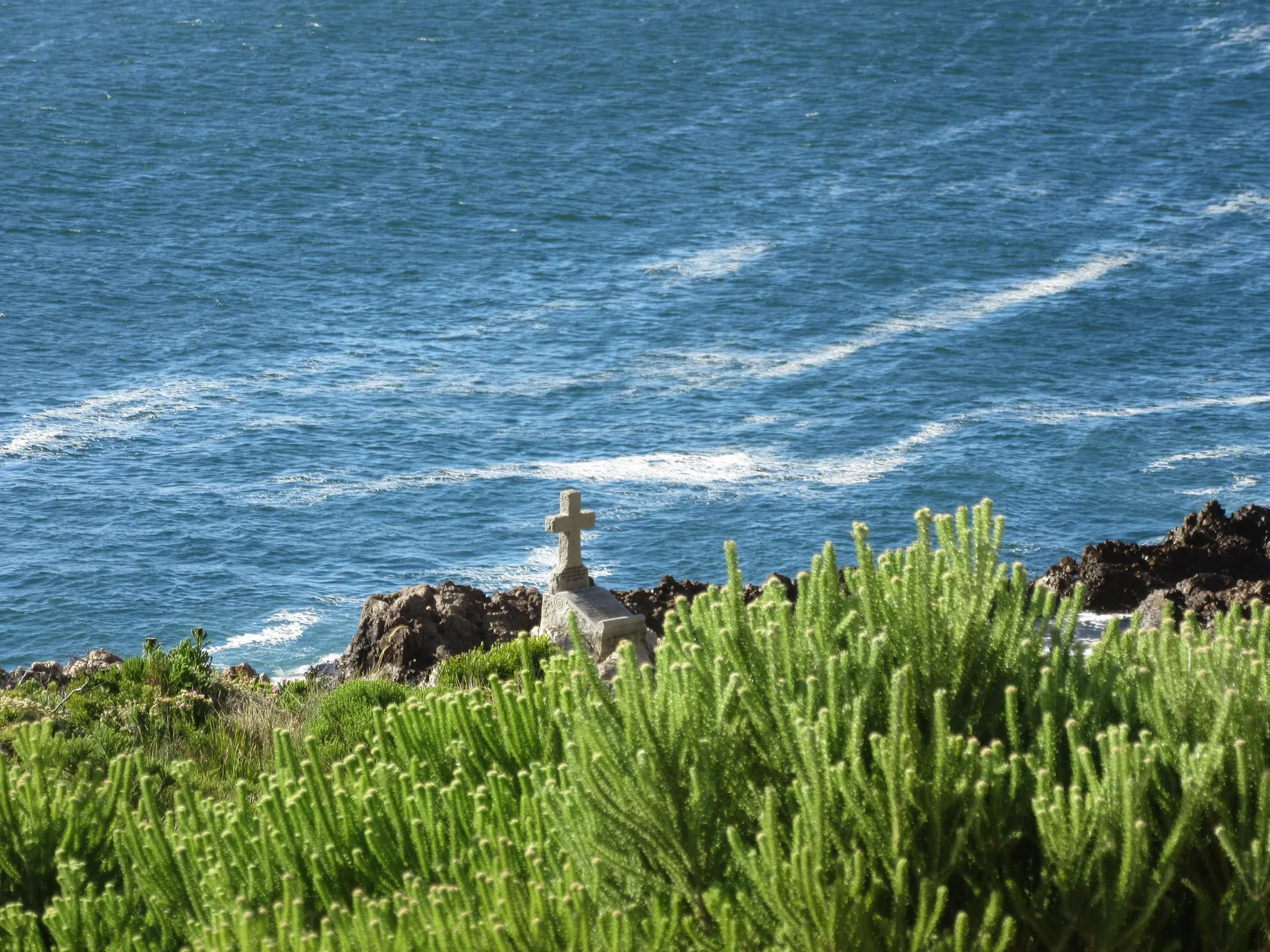 A stone cross on the shore to the Atlantic ocean along the "Whale Coast" in South Africa.