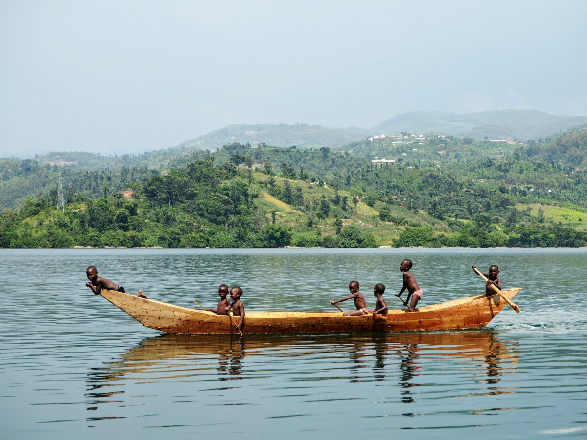 Children sailing in traditional boat in lake Kivu, Rwanda
