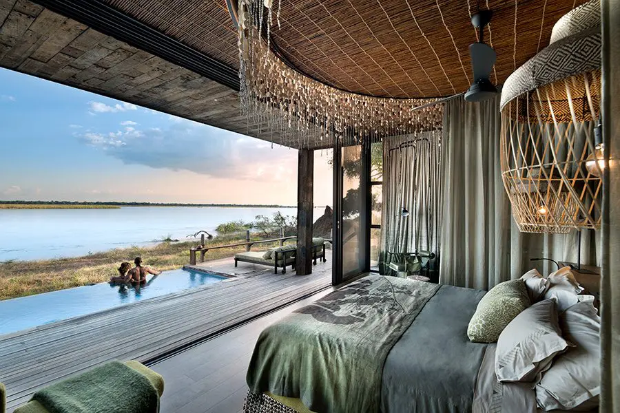 A suite and pool looking onto the Zambezi at Lolebezi