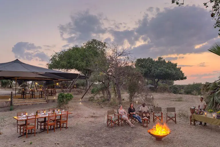 Roho ya Selous Guests enjoying sundowners by the campfire