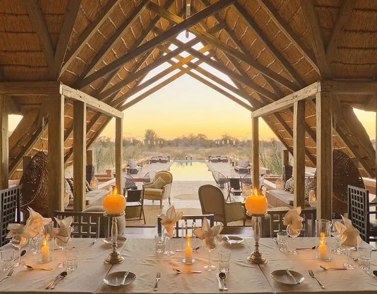 A dining table looking out to the pool at Feline Fields Lodge