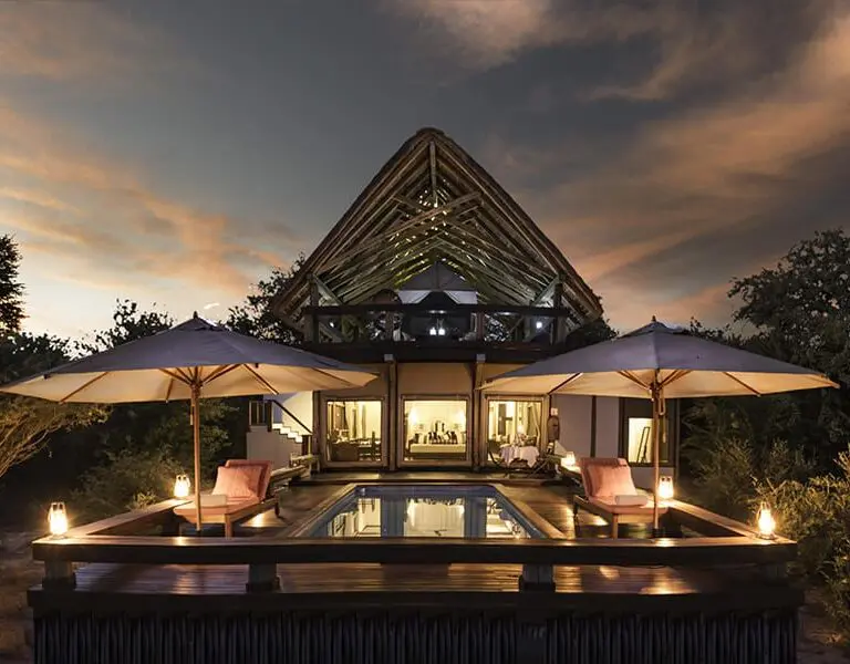 A suite deck and pool at Feline Fields Lodge after dark